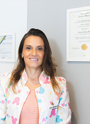Renata Riciati de jaleco colorido no consultório