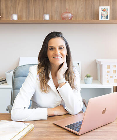 Renata Riciati sentada à mesa do consultório